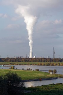 View of the green banks of the Rhine and white column of smoke from the cooling tower of the