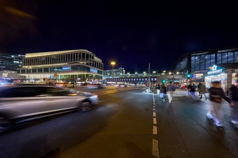 Zoologischer Garten railway station, Primark shop, vehicles and pedestrians with motion blur at