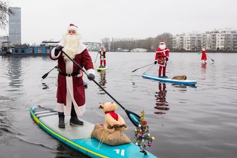 Water sports enthusiasts dressed as Santas ride SUPs on the Spree in Berlin on 14 December 2024