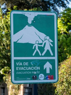 Signpost indicating evacuation route in case of a volcano eruption, Pucon, La Araucania, Chile,