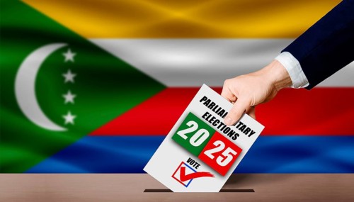 Hand holding ballot in voting ballot box with Comoran flag in background. Comoran parliamentary