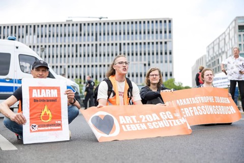 Last Generation activists with banner on Article 20A of the Basic Law = Protect Life at the