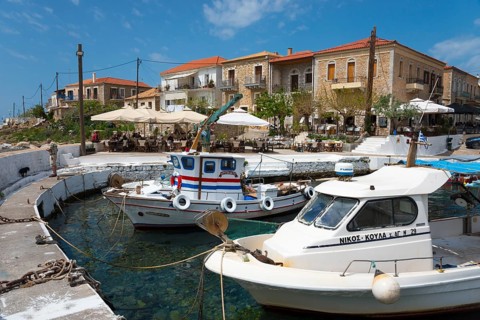 Harbour with fishing boats and Mediterranean buildings in the background. Sunny day with
