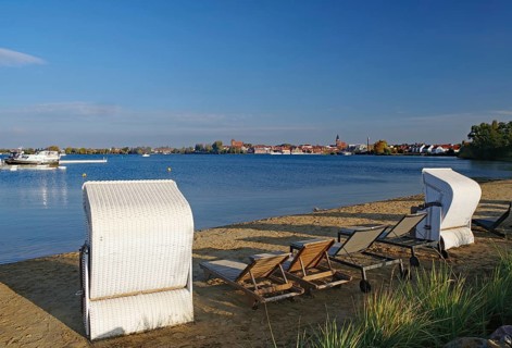 Empty beach with beach chairs and deckchairs on the lakeshore, autumn, Waren National Park,