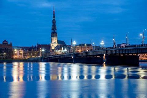 St Peter's Church and stone bridge in the morning at the blue hour, River Daugava, Riga, Latvia,