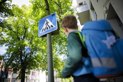 Symbol photo on the subject of schoolchildren in road traffic A six-year-old boy stands with his