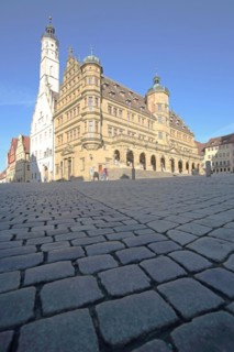 White town hall tower and Renaissance town hall, market square with cobblestones, view from below,