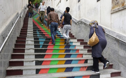 People walk down a painted staircase. The city of Tehran is changing the image of the city through