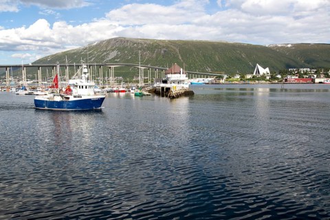 Boats at moorings and fishing boat and bridge at Tromso, Norway, Europe