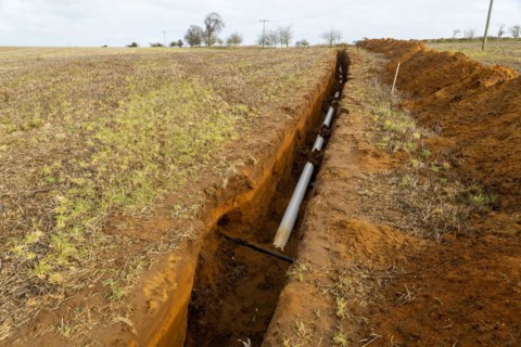 Farm irrigation water supply pipeline excavated in sandy soil, Shottisham, Suffolk, England, UK
