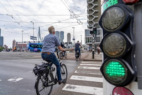 Bicycle traffic light, cyclist on cycle path, in front of the Erasmus Bridge over the Nieuwe Maas,