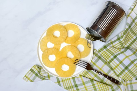 Pineapple rings on a plate and tin can