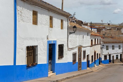 Rustic village with blue and white painted houses along a quiet street, Campo de Criptana, Ciudad