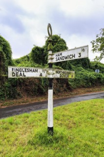 Old moss-covered signposts in the countryside, showing direction and distance to Ham, Sandwich and