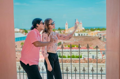 Tourist couple taking a selfie at the viewpoint of the La Merced church. Happy tourists taking self