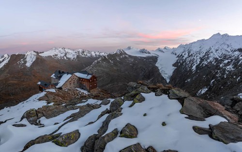 Snow-covered mountain landscape, mountain hut Ramolhaus in autumn with snow, at sunset, view of