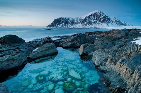Long exposure, winter at Skagsanden, rocks washed over by the sea on the beach at Flakstad,
