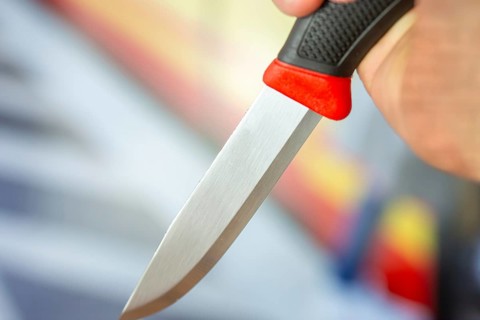 Symbolic image of a knife attack: close-up of a knife in a man's hand