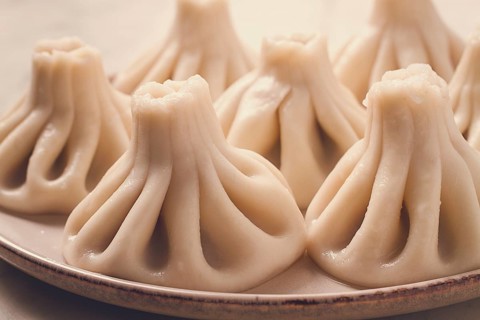Traditional Georgian dish, Khinkali Kalakuri, on a marble table, selective focus, rustic, toned