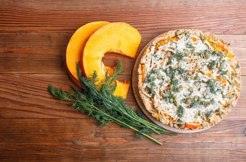 Sweet pumpkin pie with cheese and dill on brown wooden background. top view. copy space