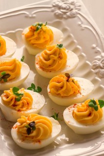 Boiled eggs stuffed with yolk with mayonnaise, on a white plate, selective focus, blurry, close-up,