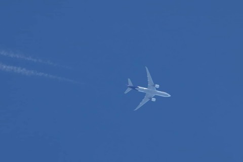 Airbus A300 jet aircraft of Fedex airlines flying in a blue sky with a vapor trail or contrail
