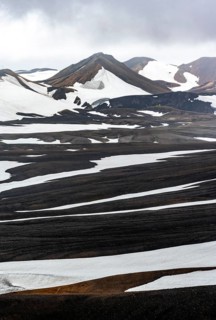 Dramatic volcanic landscape with mountains and snow, at Höskuldsskáli hut in Hrafntinnusker,