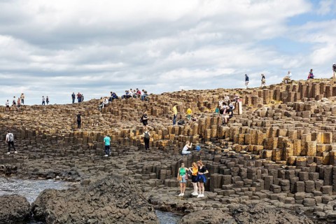 Groups of people on an impressive rock formation on the coast, Giant Causeway