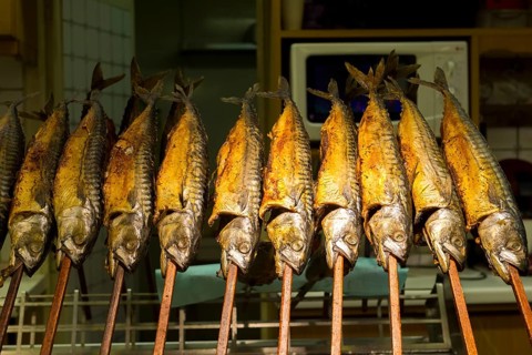 Grilled mackerel on sticks at a stand with golden colour and traditional atmosphere, Kitchen,