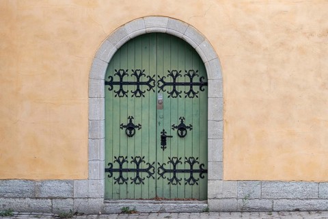 Green wooden door with black, iron fittings and round arch, Old Town, Hanseatic City of Visby,
