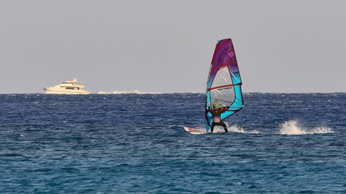 Windsurfer near a yacht in the middle of the blue sea, windsurfer, Meltemi windsurfing spot, Devils