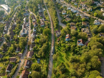 Rails and roads between densely overgrown residential areas, track construction, rail delivery for