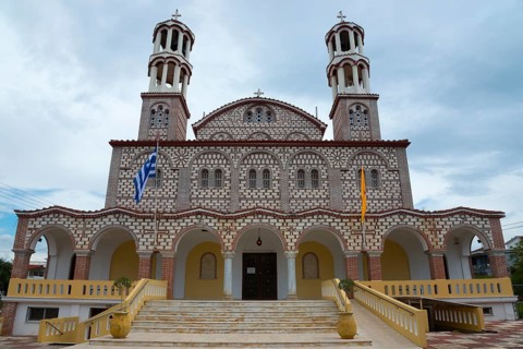 Imposing church with two towers and flags against a cloudy sky, Church of Agios Georgios, Nea