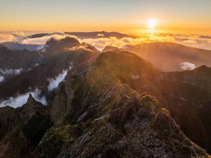 Aerial drone view of mountains over clouds near Pico Ruivo on sunset. Madeira island, Portugal,