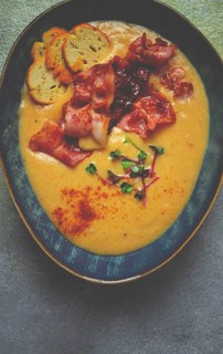 Pumpkin cream soup, curry, fried bacon, bruschetta chips, micro-greens, top view, no people