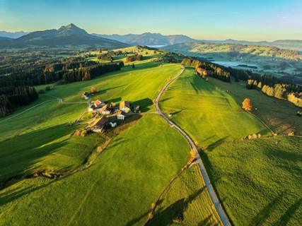 Mountain range near village Wertach, view to mt. Gruenten, sunrise, fog in valley, traditional