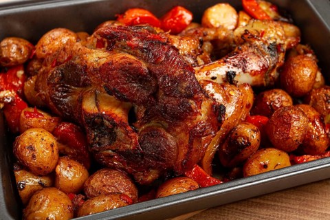 Pork knuckle, baked with vegetables, new potatoes, on a baking sheet, homemade, no people