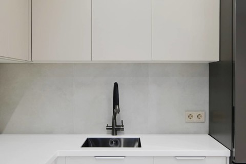 A contemporary kitchen showcases clean lines with minimalistic cabinetry in light colors. The