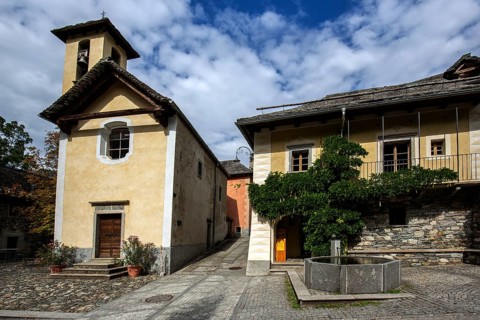 Church and typical Ticino stone houses in the mountain village of Bordei, Centovalli, Canton