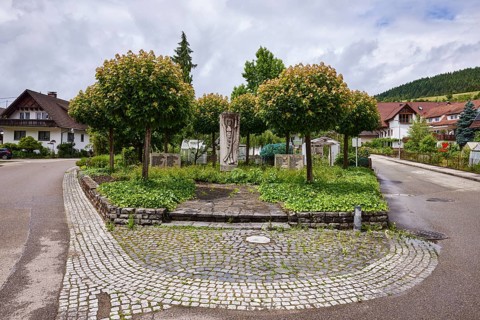 Memorial to the fallen of the 1st World War, green area with trees, residential buildings,