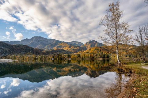 On the shore of Lake Lake Kochel with reflection, autumn landscape with mountain peaks Herzogstand
