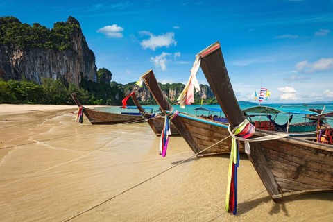 Long tail boats on tropical beach in Thailand