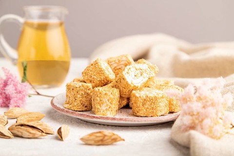 Traditional turkish delight (rahat lokum) with glass of green tea on a gray concrete background and