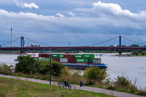Cargo ship, loaded with containers, on the Rhine near Duisburg, the wheelhouse is raised to ensure