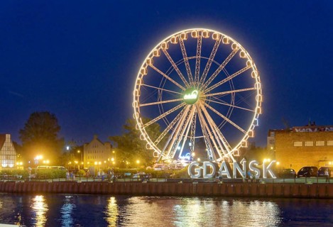 The Ferris wheel illuminated in the evening on the Motlawa, Motlawa, and the lettering Gdansk,