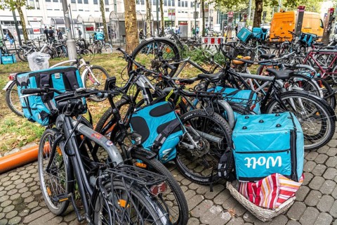 Wolt delivery service, parked bikes of bicycle couriers with thermal backpack, in front of the main