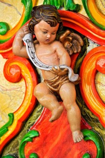 Wooden figure, colourfully painted, cherub at a carousel organ, fairground organ, historic