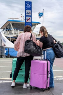 Tourists with luggage, wheeled suitcases, at Amsterdam Centraal railway station, Netherlands