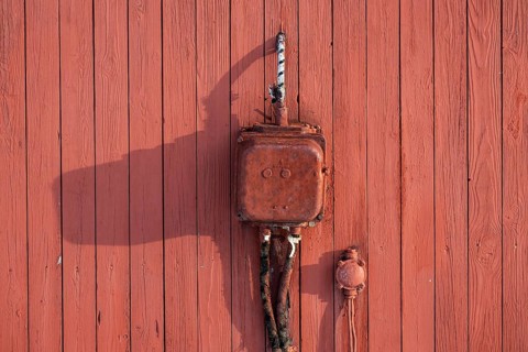Old electrical junction box from Siemens, red painted wooden wall, Ny-Ålesund, Kongsfjord,