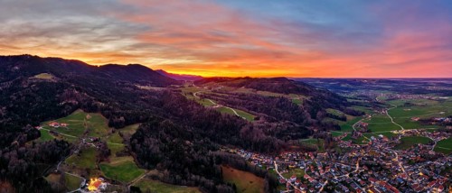 Evening mood over a village with hills and valleys at sunset, brightly coloured sky, Bad Feilnbach